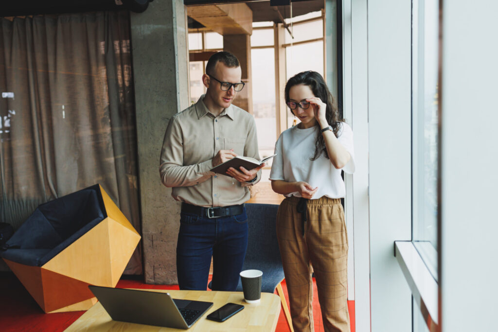 Young male and female colleagues work in a spacious office. Successful people are working on a new business project. Collective work in the office